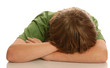 young teenage boy with head down in arms
