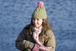 Foto: Smiling girl on a cold sunny day outdoors by water Smiling girl on a cold sunny day outdoors by water