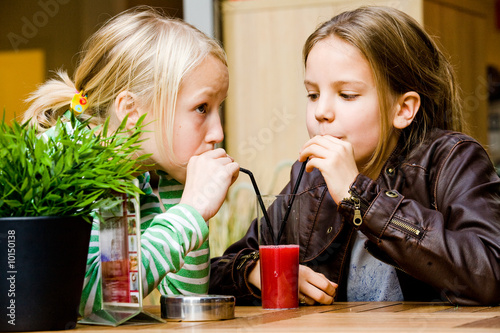 Photo: Two cute children having a drink toghether Two cute children having a drink toghether