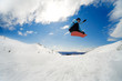 Snowboarder jumping through air on blue sky background