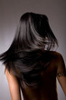 Beautiful dark hair from behind on grey background