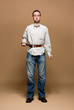 Young man with a belt tightened to the extreme