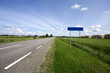 Country highway and blank city name sign.