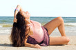 The young woman lies on sand at sea coast