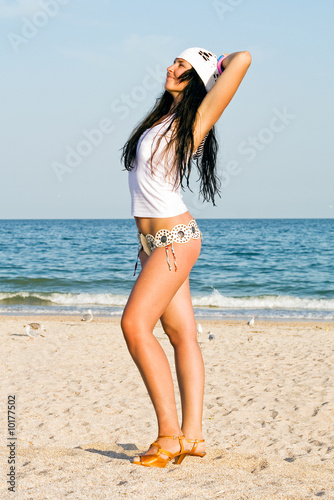 Foto: The young woman on sand at sea coast The young woman on sand at sea coast