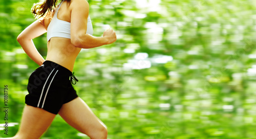 Foto: Beautiful young woman runner in a green forest. Beautiful young woman runner in a green forest.