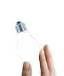 Fragile light bulb in female fingers isolated