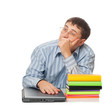 young adult man sitting with laptop, books and thinking