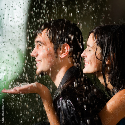 young couple kissing in the rain. Young happy amorous couple
