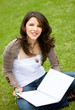 female university student with a notebook outdoors