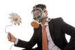 A businessman with a gas mask looking to an artificial flower