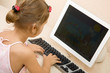 Foto: Little girl typing text at the home computer Little girl typing text at the home computer