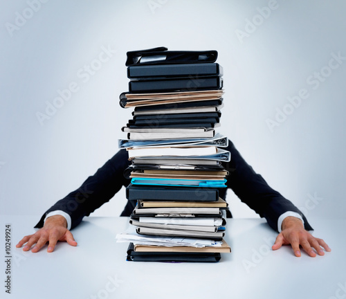 Photo: Man hiding behind files on isolated on white Man hiding behind files on isolated on white