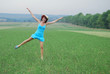 happy young woman dansing on the green grass
