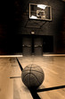 Basketball on court with hoop in the background Basketball on court with hoop in the background
