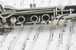 Middle of a clarinet with keys lying across some sheet music