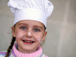a young girl wearing a chef's hat