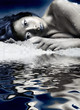 Asian girl laying on crushed ice, water in foreground