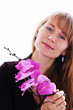 Beautiful young smiling woman with violet orchids