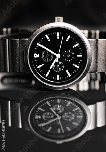 Photo: Men's wrist watch on black background. Studio shoot. Men's wrist watch on black background. Studio shoot.