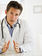 doctor at desk in office.