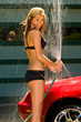 sexy girl car wash spraying water from the hose