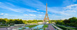 Eiffel Tower panorama, with cloudy sky and park.