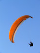 Paraglide (parachute) flying under a clear blue sky Paraglide (parachute) flying under a clear blue sky