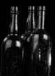 Bottle and drops of a condensate on a black background