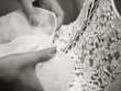 Bride getting her white wedding dress tied at the back