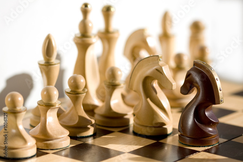 Chess pieces - white pawn looking down the chessboard