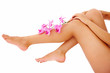 Woman holding orchid branch over her legs copyspace