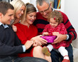 Happy family sitting together opening christmas presents