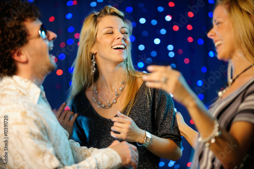 Photo: Happy friends dancing in the club Happy friends dancing in the club