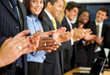 business team clapping in an office facing the camera
