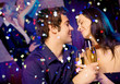 Young happy couple with champagne glasses at celebration