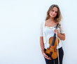 Woman holding violin and standing beside copyspace