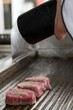 Chef add spycies to frying beef