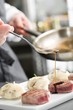 Chef add sause to a beef on professional kitchen