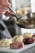 Chef add sause to a beef on professional kitchen