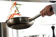Chef hands with frying pan on professional kitchen