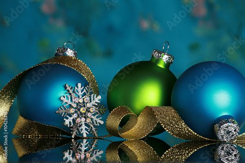 Photo: Christmas ornaments and snowflake on reflective surface, Christmas ornaments and snowflake on reflective surface,