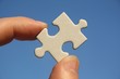 Foto: Pièce de puzzle blanche entre les doigts d'un homme Pièce de puzzle blanche entre les doigts d'un homme