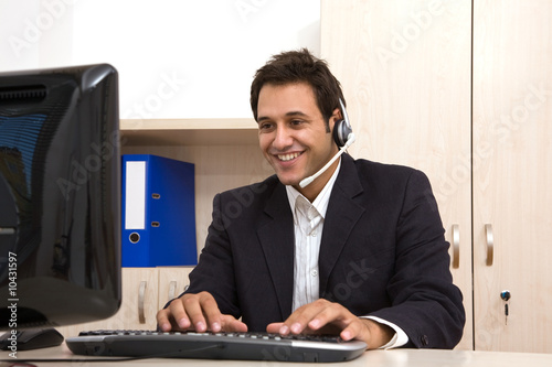 Photo: male customer service representative at the office with computer male customer service representative at the office with computer