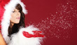 Attracive girl in santa cloth blowing snow from hands.