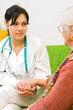 A young female doctor talking whit an old woman.