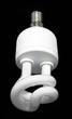 A white energy saving lightbulb on a black background