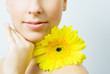 Young woman with yellow gerbera flower.