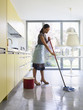 Young woman mopping kitchen floor Young woman mopping kitchen floor