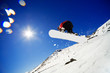 Snowboarder jumps in air with blue sky background